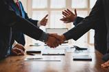 Two parties shake hands in a business meeting