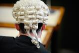 A man wears a barrister wig