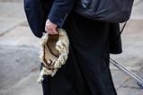 A barrister holds his wig on his way to court