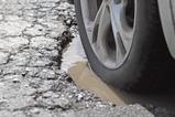 A car drives through a pothole