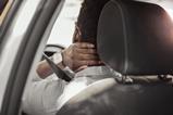 A driver holds his neck in pain