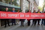 Victims of the Post Office scandal hold a banner outside the inquiry