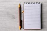 A pen and notepad next to each other on a table