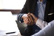 Businessmen shaking hands after signing contract