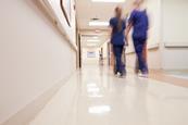 Blurred image of medical staff walking down hospital corridor