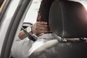 A driver holds his neck in pain