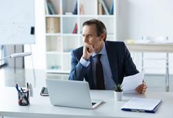 Businessman holds a contract while working at his desk