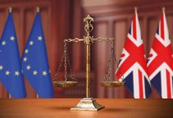 Justice scales with EU and UK flags