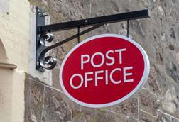 Post office sign hanging outside shop