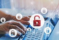 A man types on a laptop with an open padlock image covering the keyboard