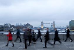 Commuters walk across London Bridge
