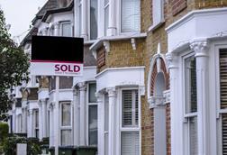 Sold sign outside row of terraced houses