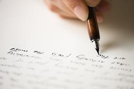 A close up of a hand writing on a piece of paper with a fountain pen