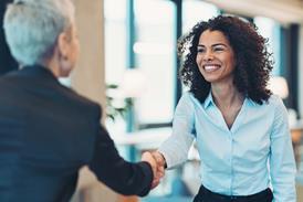 Two business women shake hands