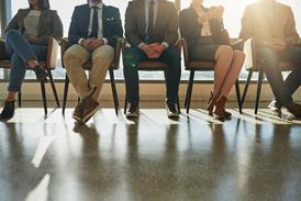 A group of people sit waiting to be seen