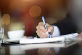 A man writes in a notepad