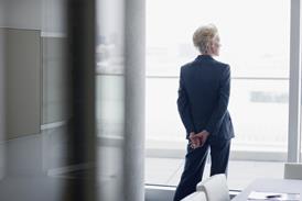 An older businesswoman looks out of an office window