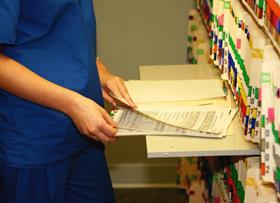 An anonymous doctor looks through hospital files