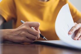 A woman signs a document