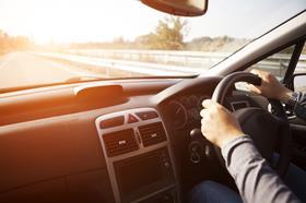 Close up shot of car dashboard with driver behind the wheel
