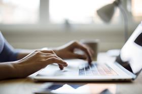 Hands typing on laptop