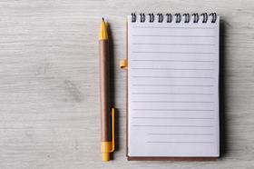 A pen and notepad next to each other on a table