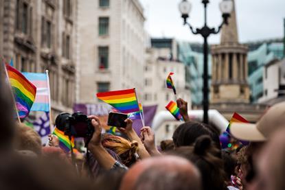 People waving rainbow flags during Gay Pride parade