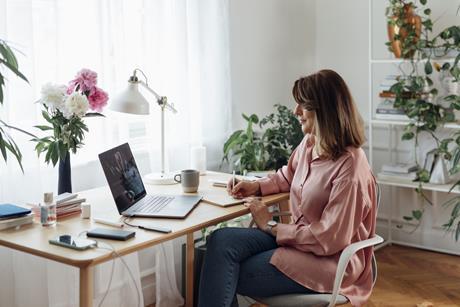 A woman makes notes while sitting at a desk