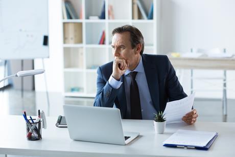 Businessman holds a contract while working at his desk