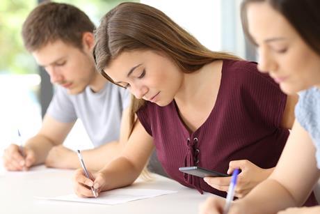 A student checks her phone during school exam