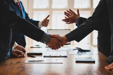 Two parties shake hands in a business meeting