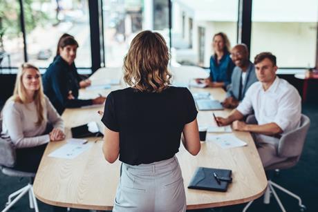 A woman leads a team meeting