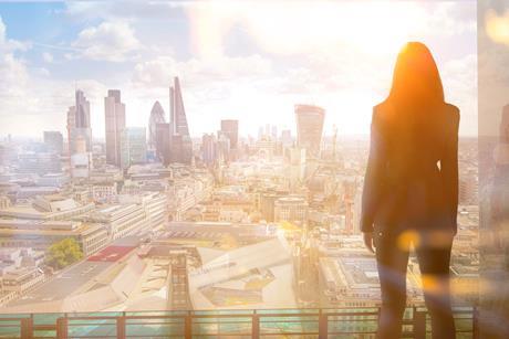 A City worker looks out over the City of London skyline