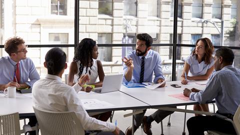 Colleagues talk around a table