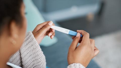 A woman reads a pregnancy test