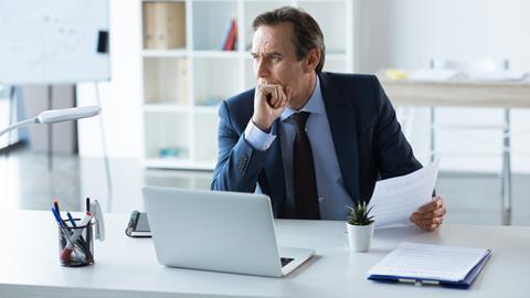 Businessman holds a contract while working at his desk