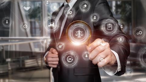A man in a suit holds up a magnifying glass to a graphic of justice scales