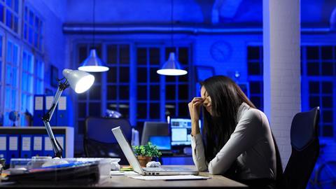Office worker sat at desk late at night