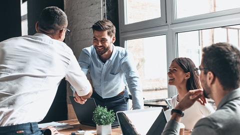 Colleagues greet eachother in the office