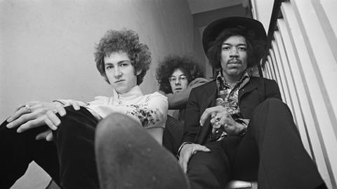 Jimi Hendrix seated on right with, on left, Mitch Mitchell and, behind in centre, Noel Redding