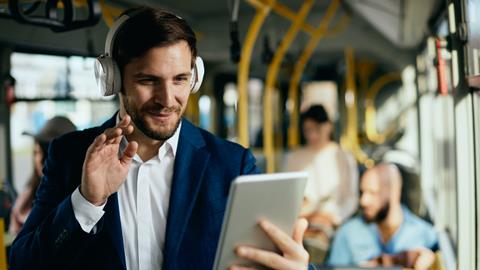 A businessman takes a video call while on a bus