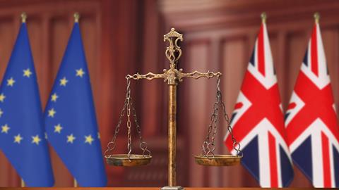 Justice scales with EU and UK flags