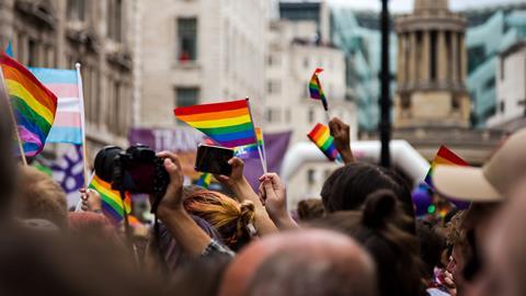 People waving rainbow flags during Gay Pride parade