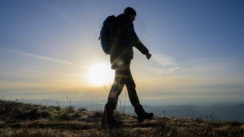 Male hiker walks up a mountain