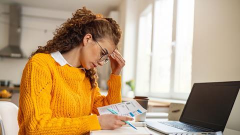 A young woman looks at bills at home