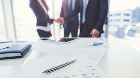 Team handshake in a boardroom after business deal