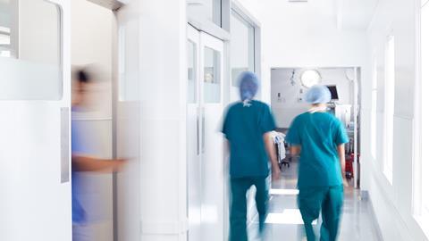 Surgeons wearing scrubs walk to theatre in hospital