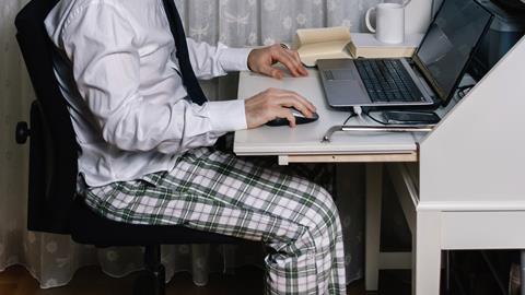 Man on laptop at desk in pyjamas