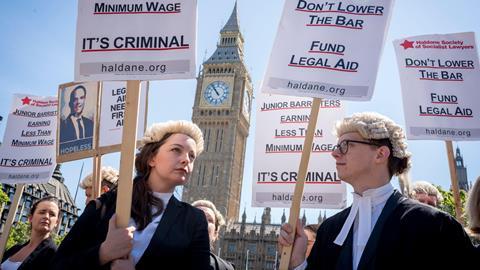 Barristers hold placards in Parliament Square as they strike over legal aid funds