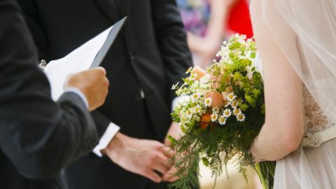 An officiant conducts a wedding ceremony with a bride and groom